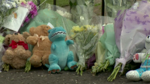 Teddy bear and flower tributes on a street