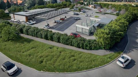 A computer generated image of the service station. It has a building to the left housing a shop, a canopy in the middle covering the fuel pumps and car washes in the foreground. In the far distance is the coffee shop. The site is surrounded by hedges. 
