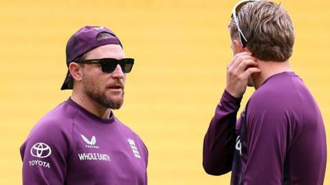 Brendon McCullum (left, facing camera) speaking to Joe Root