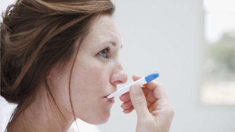 Woman taking her temperature