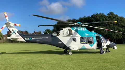A helicopter on an area of grass. 