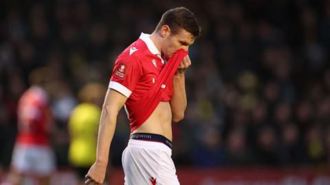 Paul Mullin holds his shirt to his face while playing for Wrexham
