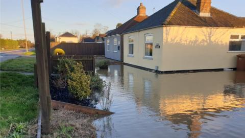 A bungalow surrounded by sewage water