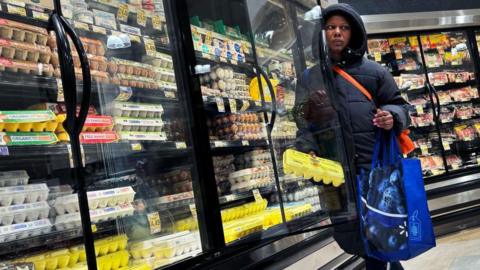 A shopper takes a carton of eggs from the cooler in a grocery store in Washington, D.C., on Saturday, April 6, 2024