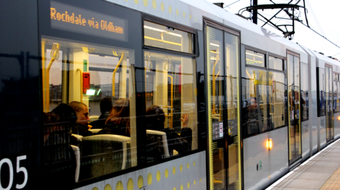 A Bee Network tram with people sat inside. 