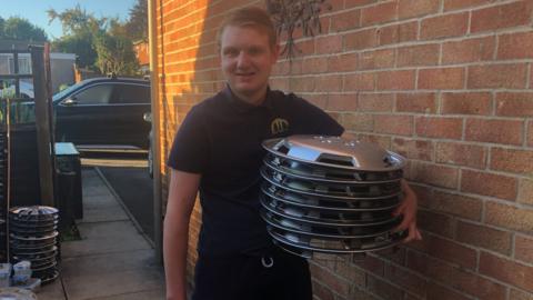 Matthew holding hubcaps