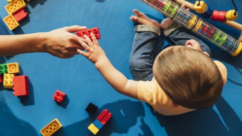 Child holding plastic brick