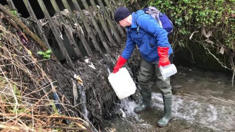 Scientist takes samples from a combined sewer overflow on the River Tame