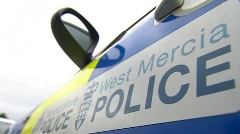 A close-up shot of the side of a police car with "West Mercia Police" emblazoned on the door.