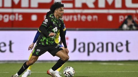 Oluwaseun Adewumi in action for Cercle Bruges wearing a black and green playing shirt, black shorts and black socks