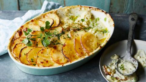 A white oval oven dish with potato and cauliflower bake inside. 