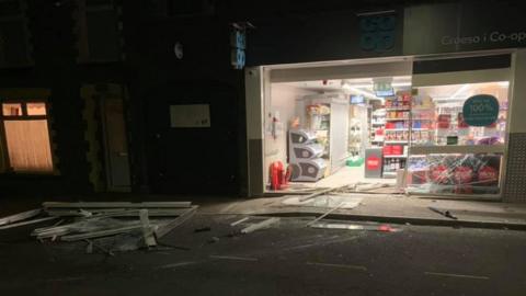 Debris from the smashed frontage of the store lying strewn across the roade