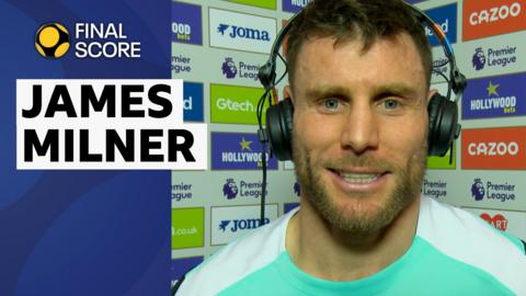 James Milner smiles in a blue and white Brighton training top