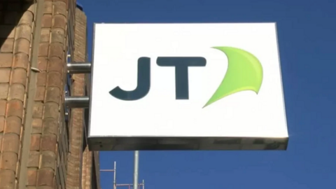 A picture of the JT logo - it's a white background with the letters 'JT' on it, with a green shape next to it.