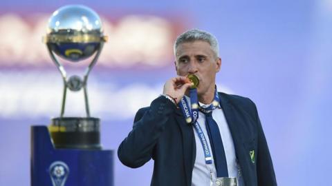 Hernan Crespo kisses his Copa Sudamericano medal with the trophy in the background
