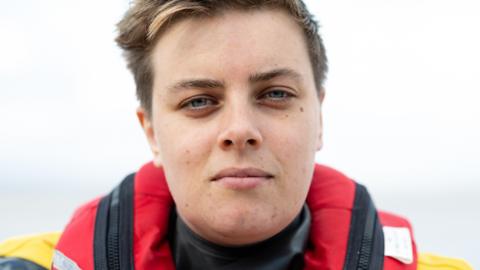 Susan Beaton from RNLI Portishead. She has short brunette hair and blue eyes. She is pictured outside, wearing her yellow and red high vis jacket. She is looking directly at the camera with a slight smile. 