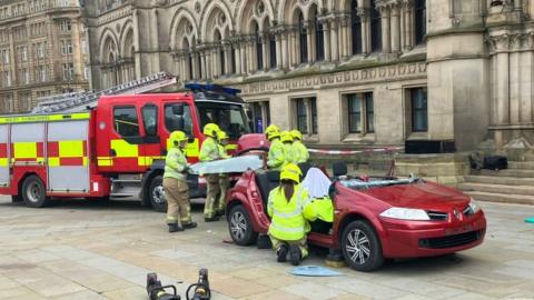 Firefighters demonstrate cutting a roof of a car in Leeds