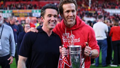 Rob McElhenney and Ryan Reynolds co-owners of Wrexham holding the cup