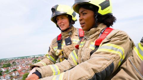 Emma Louise and Jade Konkel in firefighting uniforms.