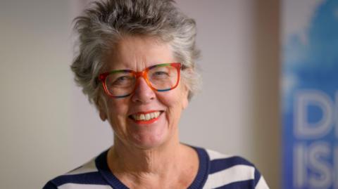 Dame Prue Leith is wearing colourful glasses and has short grey hair.