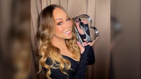 Mariah Carey holding the new BRIT Billion award