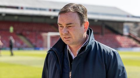 Derek Adams walking at the stadium while manager of Morecambe