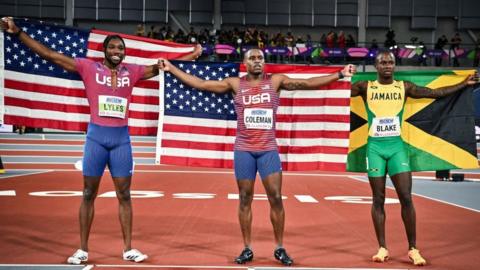 Christian Coleman and Noah Lyles hold American flags