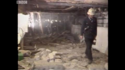 A policeman walks through the destroyed interior of a bombed Berlin discotheque