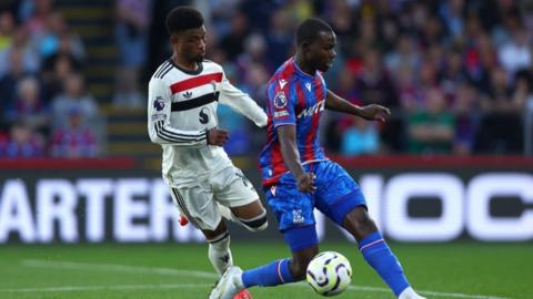 Tyrick Mitchell and Amad compete for the ball