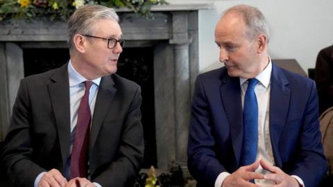 Sir Keir Starmer (left) a man with grey hair, glasses, dark suit, purple tie and Micheal Martin, a man with grey hair, blue suit and blue tie.