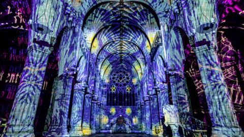 A light projection on the interior walls of a cathedral.