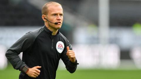 Assistant referee Rob Smith warms up