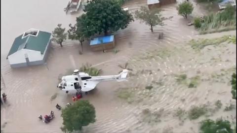 Aerial shot of a helicopter rescuing survivors in a flooded area
