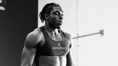 Uar Bernard, seen wearing a cropped black support vest over his upper chest