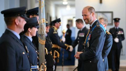 The Prince of Wales meeting parade executives and exchanging a smile and laugh with them