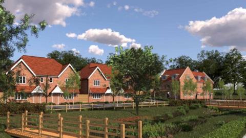 An illustration of proposed new homes in Warlingham village in Surrey. There are a series of brick houses with an area of grass in front of them. 