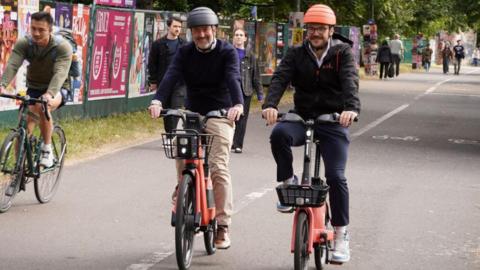 Two cyclists riding towards the camera.