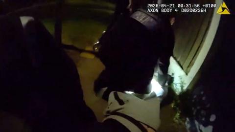 Police officer on the ground arresting a suspect.