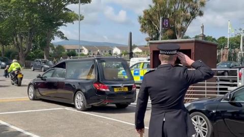 Chief Constable Russ Foster saluting the hearse