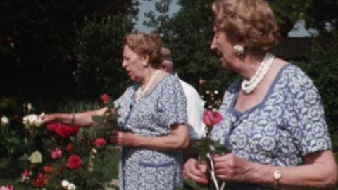 Elsie and Doris Waters (aka Gert and Daisy) pick flowers from a garden