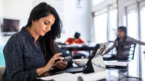 Female office worker looking at her mobile phone