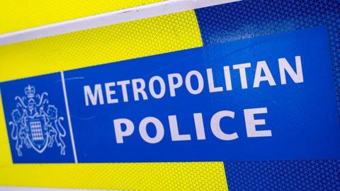 The side of a Met Police van with stickers in blue and hi-viz yellow marked Metropolitan Police