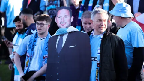 Coventry City fans with a cardboard cut-out of boss Frank Lampard before their game at Blackburn
