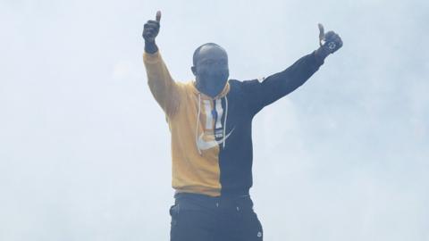 A protester gestures at anti-riot Kenyan police officers who were dispersing them during a demonstration against tax hikes as Members of the Parliament continue to debate the Finance Bill 2024 in downtown Nairobi on June 20, 2024.