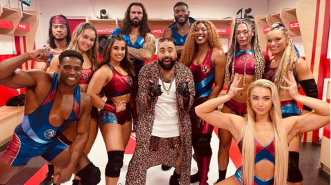 Chabuddy G stands in the middle of the Gladiators in the changing rooms.