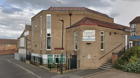 General view of Springwell Gardens Community Centre, a red-brick building with its name on a sign.