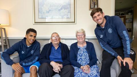 John Stones and Rico Lewis with City fan Allan Grafton