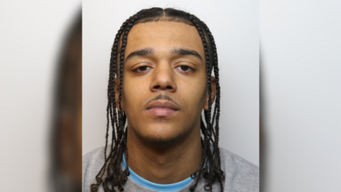 A police custody photo of Marlon Barnes wearing a grey jumper and a blue t-shirt