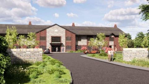 A computer generated images of a care home. the building is two storeys with a sloping grey roof. In front is a grey road with two people walking on a pavement.