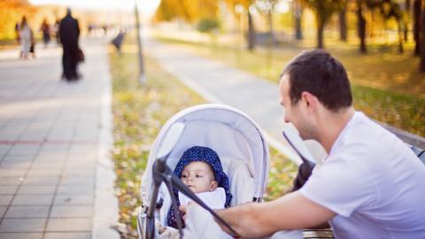 A father with his baby in a pram.